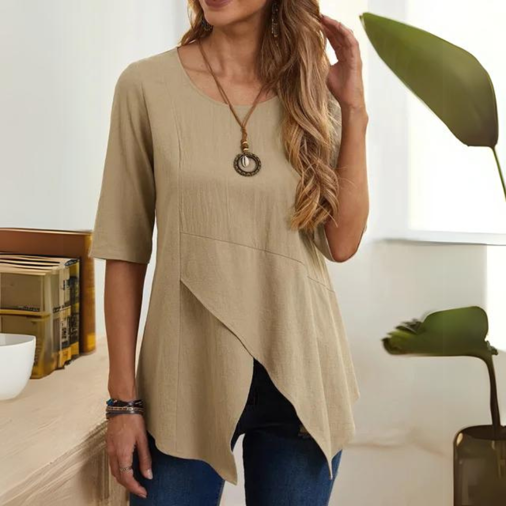Blusa beige da donna con maniche a tre quarti, design asimmetrico, collana pendente, abbinata a jeans. Moda casual elegante per l'estate.