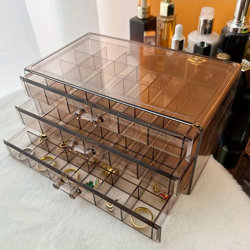 Cassettiera trasparente in plastica con tre cassetti, ideale per organizzare gioielli e accessori. Design elegante, perfetto per camera da letto o bagno.