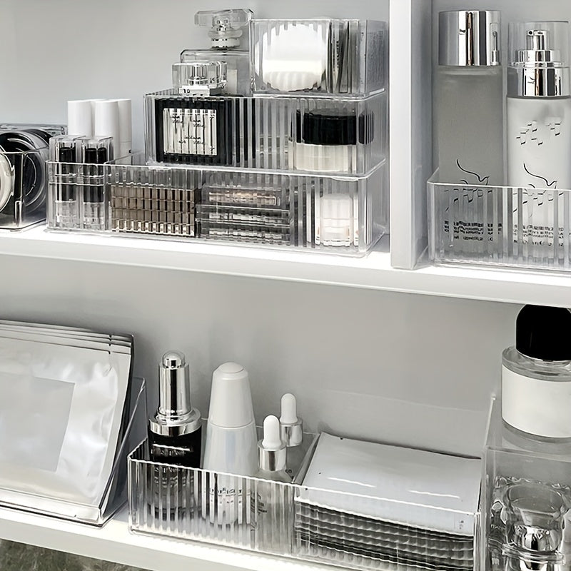 Organizzatore trasparente per cosmetici su scaffale bianco, contenente profumi, creme, sieri e trucchi. Soluzione elegante per l'archiviazione del trucco.