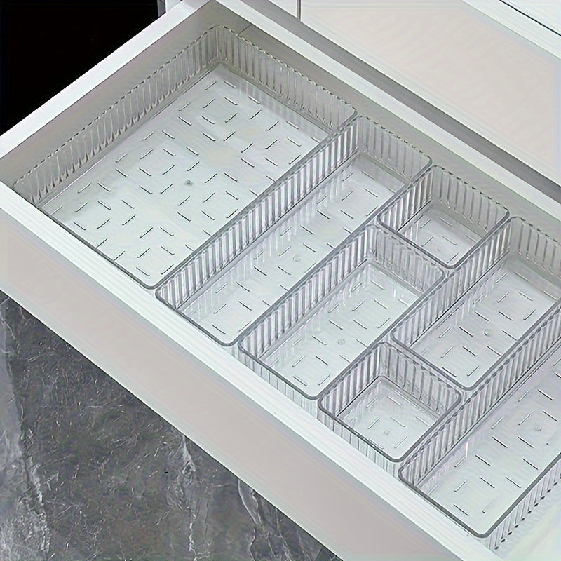 Cassetto cucina con divisori trasparenti in plastica, organizzatore modulare per posate e utensili, design moderno, ottimizzazione spazio.
