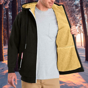 Giacca invernale uomo nera con interno in pile beige, cappuccio, zip frontale, ideale per escursioni invernali. Sfondo bosco innevato.