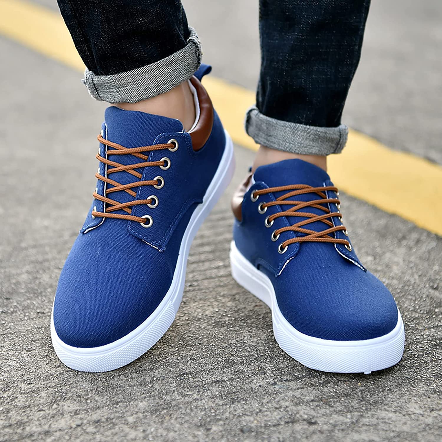 Scarpe da uomo casual blu con lacci marroni, suola bianca, indossate su strada asfaltata. Scarpe eleganti e comode per look urbano.