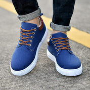 Scarpe da uomo casual blu con lacci marroni, suola bianca, indossate su strada asfaltata. Scarpe eleganti e comode per look urbano.