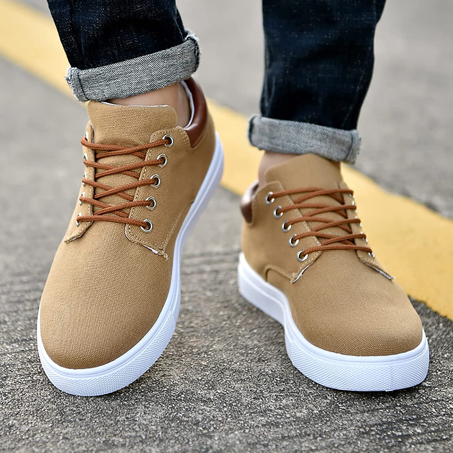 Scarpe da ginnastica casual beige da uomo, con lacci marroni e suola bianca, indossate su strada asfaltata. Moda urbana, calzature comode.
