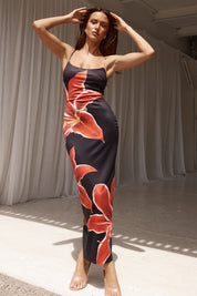 Abito lungo nero con stampa floreale rossa, donna in posa elegante. Moda estiva, abbigliamento femminile, stile casual chic.