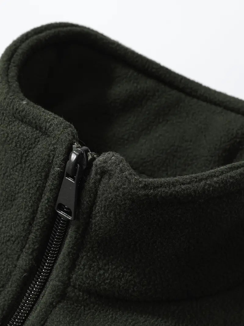 Giacca in pile verde scuro con cerniera nera, collo alto. Tessuto caldo e morbido, ideale per l'inverno. Abbigliamento outdoor uomo.