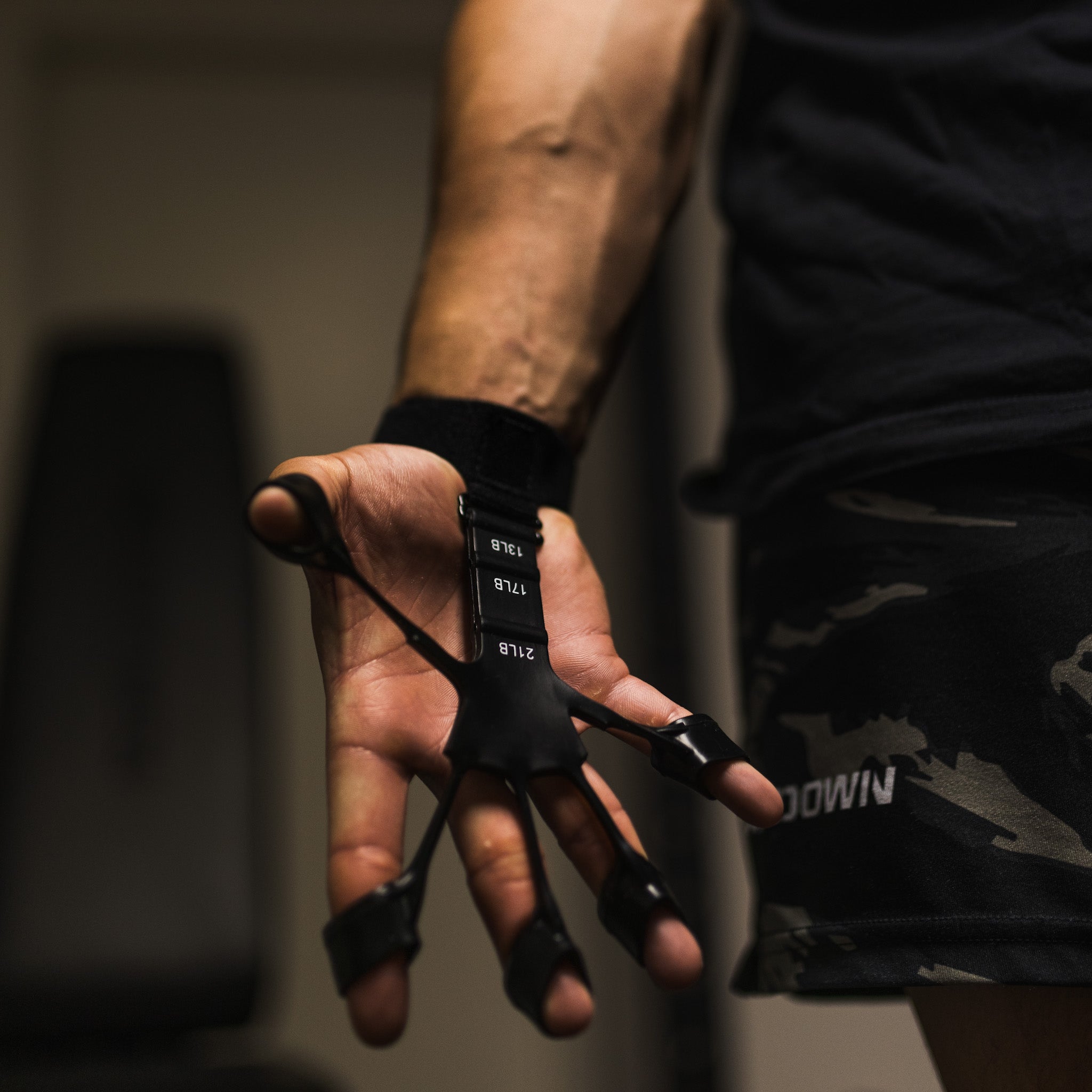 Guanto da allenamento nero per potenziamento dita, indossato da uomo in palestra. Accessorio fitness per migliorare forza e resistenza mani.