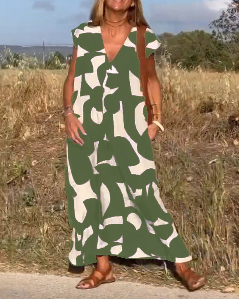 Abito lungo estivo verde e bianco con motivo astratto, indossato da donna all'aperto. Perfetto per moda casual, stile boho chic.