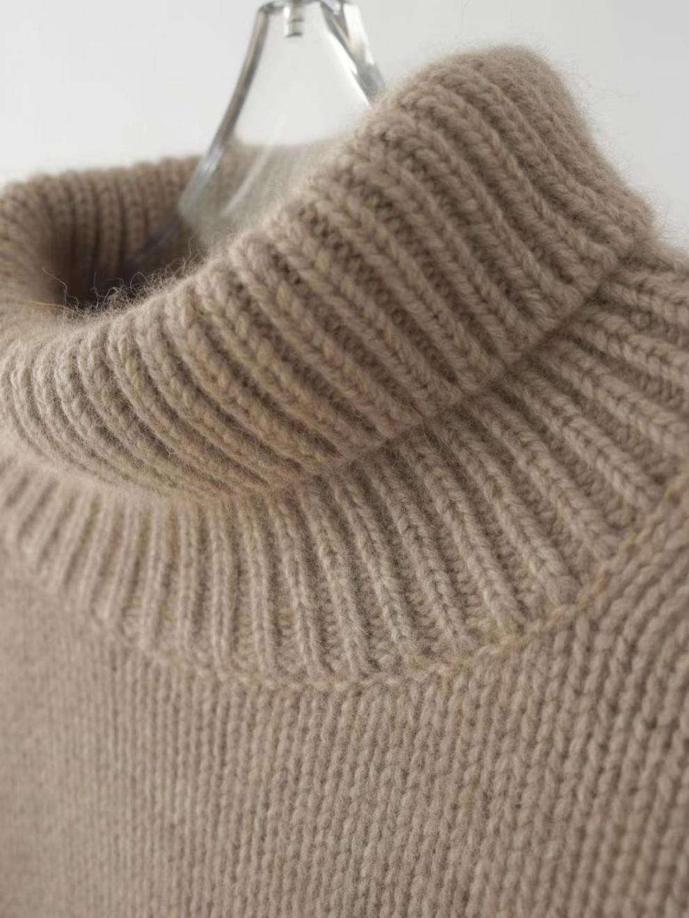 Maglione in cashmere beige con collo alto a coste, tessuto morbido e caldo, ideale per l'inverno. Elegante e confortevole, perfetto per look casual.