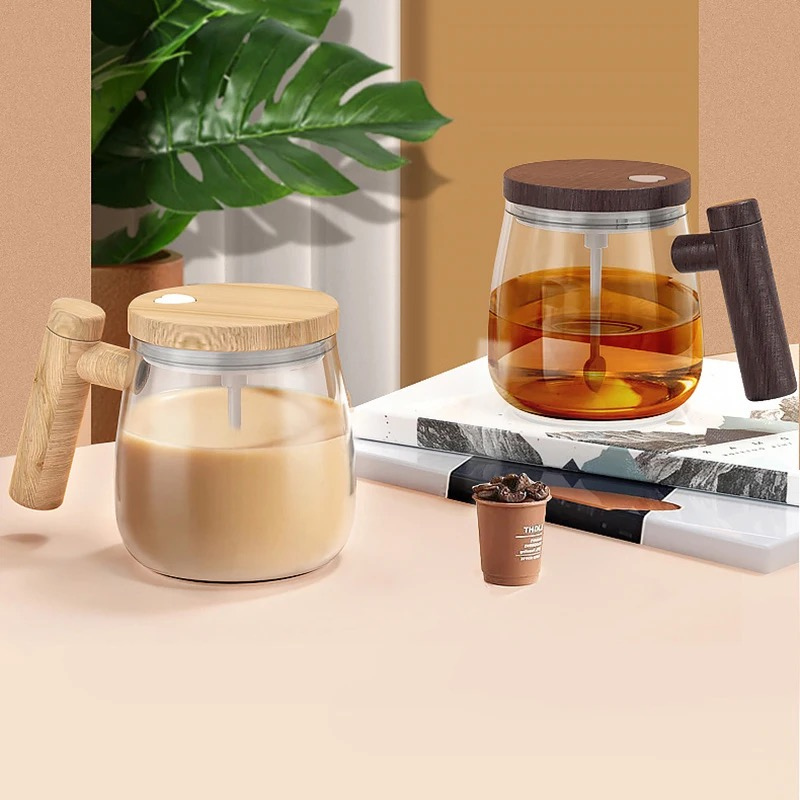 Due caraffe in vetro con coperchi in legno, una con caffè e una con latte, su un tavolo con libri e pianta decorativa. Design moderno e minimalista.