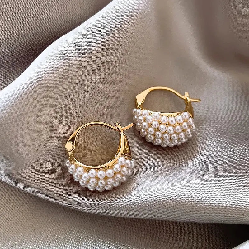Orecchini a cerchio dorati con perle su tessuto beige, eleganti e raffinati, ideali per moda donna, accessori gioielli di lusso.