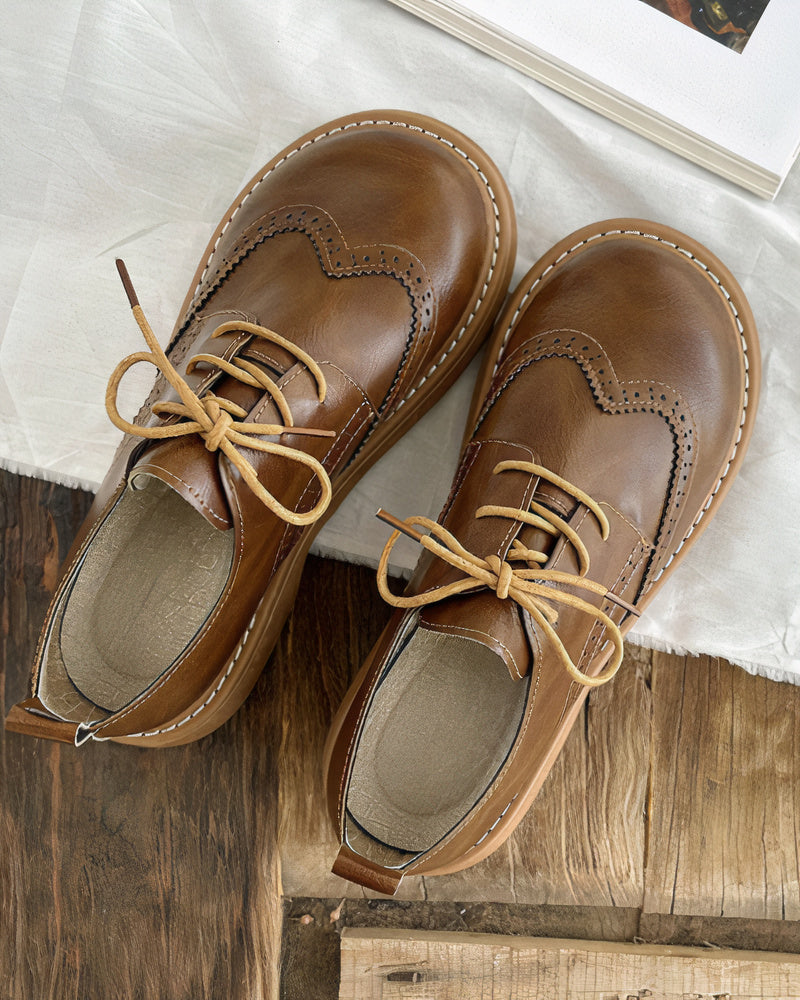 Scarpe stringate in pelle marrone per bambini, design classico con cuciture decorative, suola robusta. Ideali per look eleganti e casual.