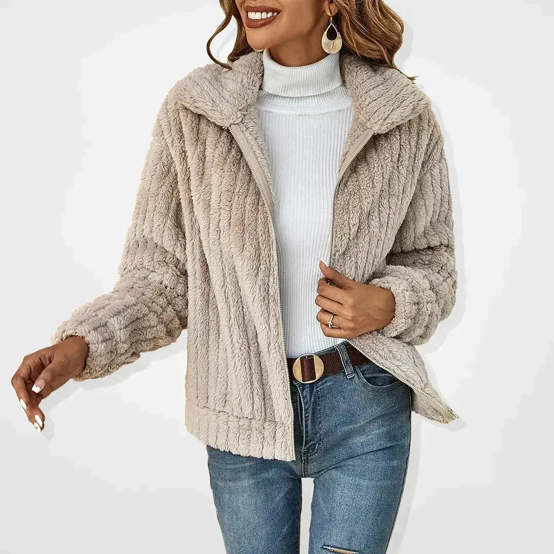 Giacca in pelliccia sintetica beige da donna, abbinata a dolcevita bianco e jeans. Moda invernale elegante e calda.