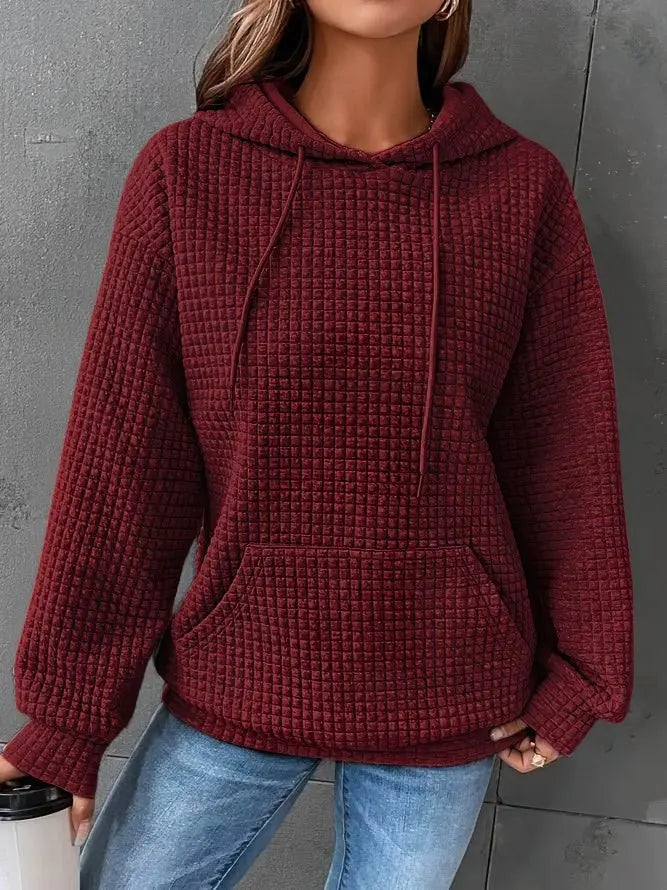 Felpa donna con cappuccio, colore bordeaux, tessuto a trama waffle, tasca frontale, maniche lunghe, abbinata a jeans. Moda casual autunno inverno.