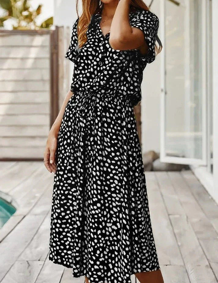 Abito lungo nero a pois bianchi, maniche corte, scollo a V, perfetto per l'estate. Moda donna casual elegante, ideale per eventi all'aperto.