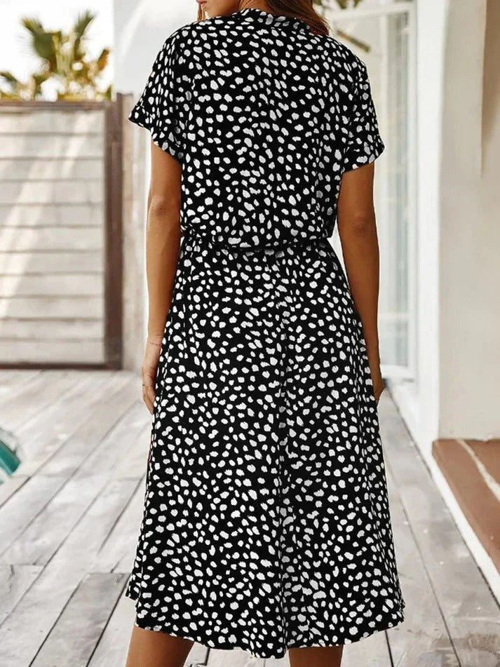 Abito estivo donna a pois bianchi e neri, maniche corte, lunghezza al ginocchio, perfetto per look casual e moda estiva.