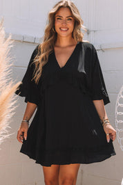 Abito nero estivo da donna con maniche a volant, scollo a V, indossato da modella sorridente. Perfetto per look casual e alla moda.