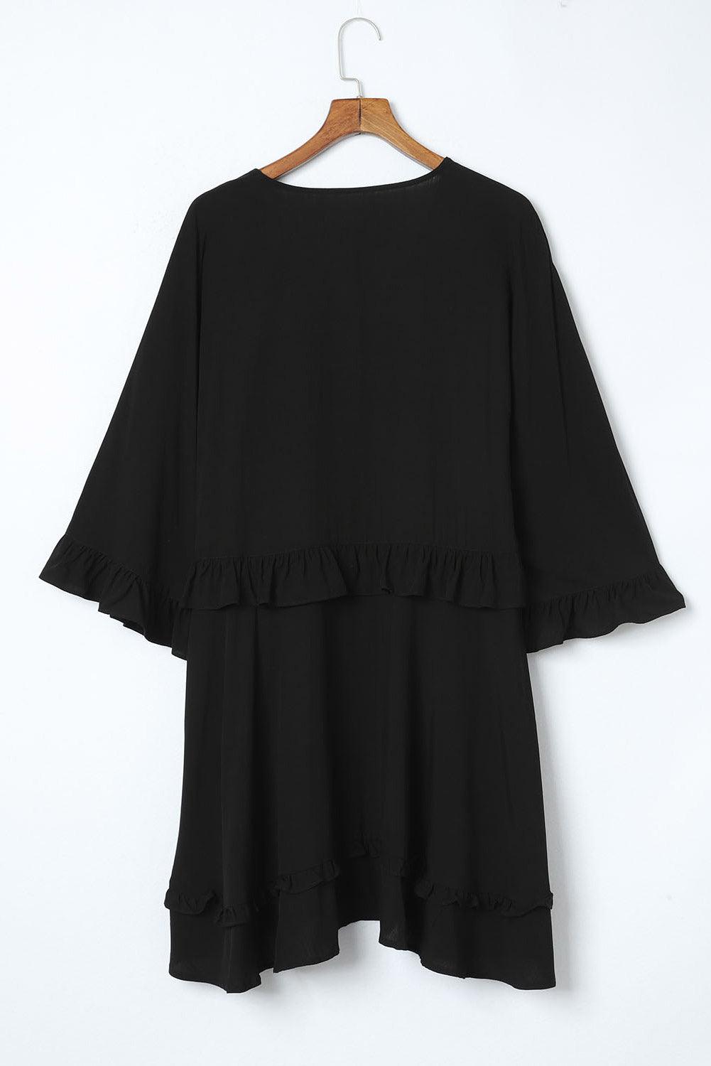 Abito nero donna con volant, maniche ampie, lunghezza media, su appendiabiti. Elegante e versatile, ideale per occasioni formali e casual.