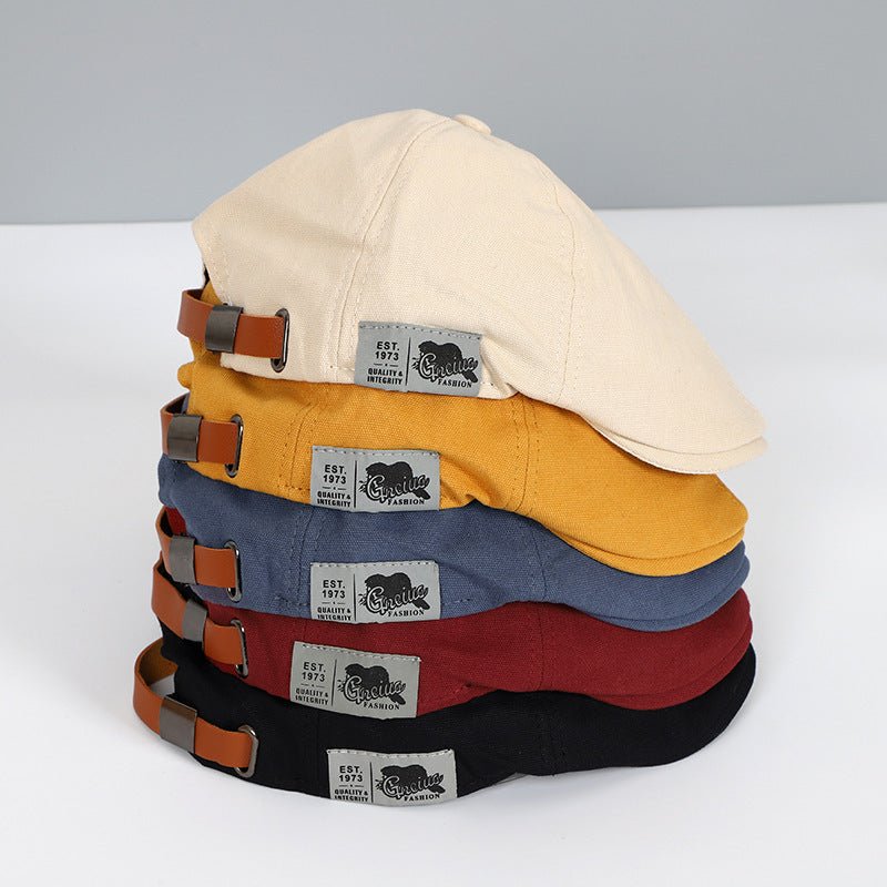 Cappelli piatti in cotone multicolore impilati, con cinturini regolabili in pelle e etichetta "Genuine" visibile. Accessori moda casual.