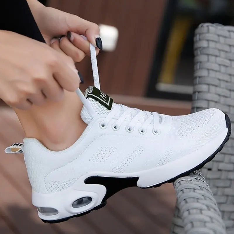 Scarpa da ginnastica bianca unisex, design moderno con suola ammortizzata e tomaia traspirante, ideale per corsa e attività sportive.