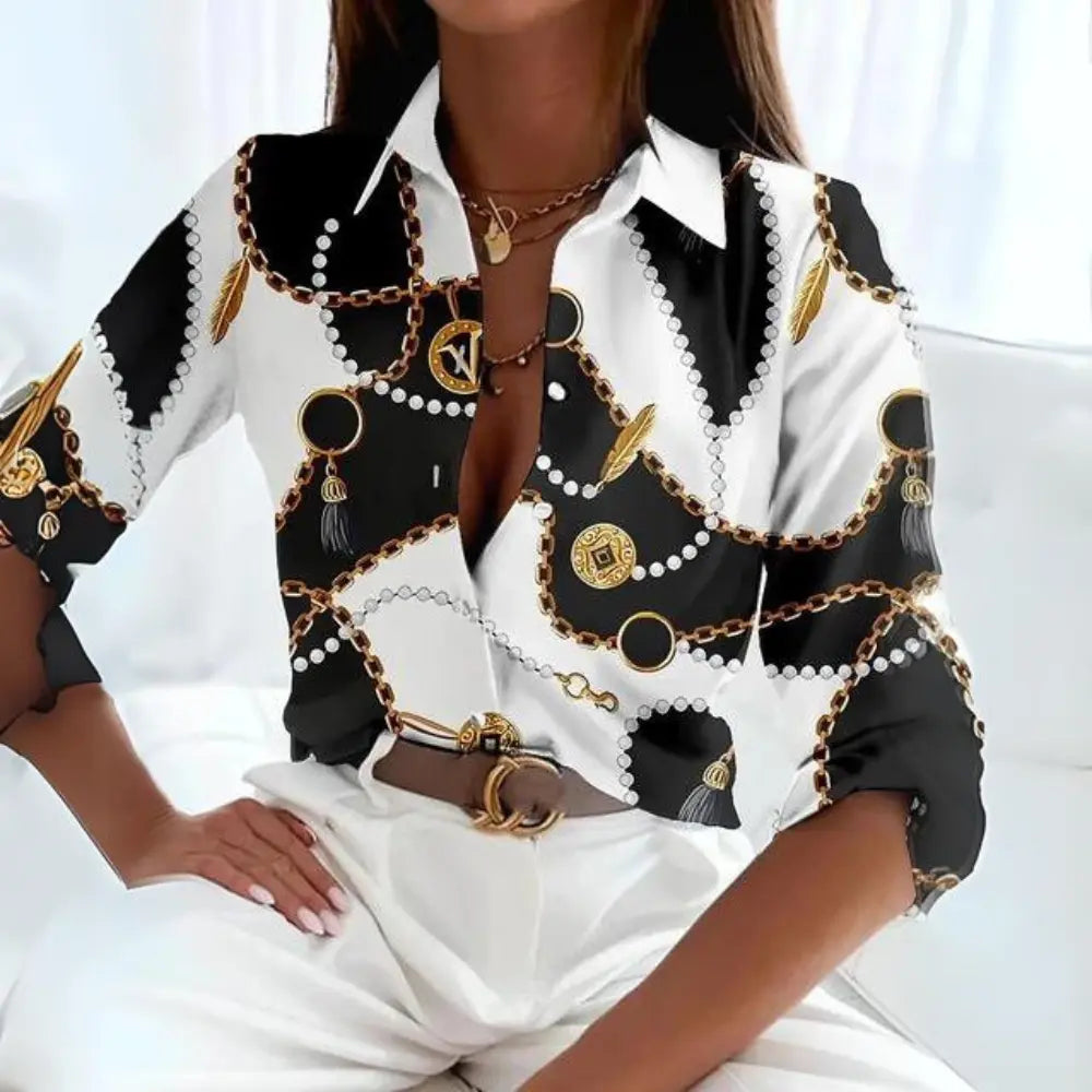 Camicia donna elegante bianca e nera con stampa catene oro, maniche lunghe, abbinata a pantaloni bianchi. Moda femminile chic e sofisticata.