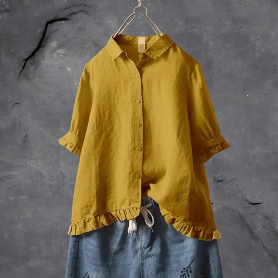 Camicia gialla in lino con maniche corte e colletto classico, abbinata a pantaloni di jeans ricamati. Moda casual estiva per donna.