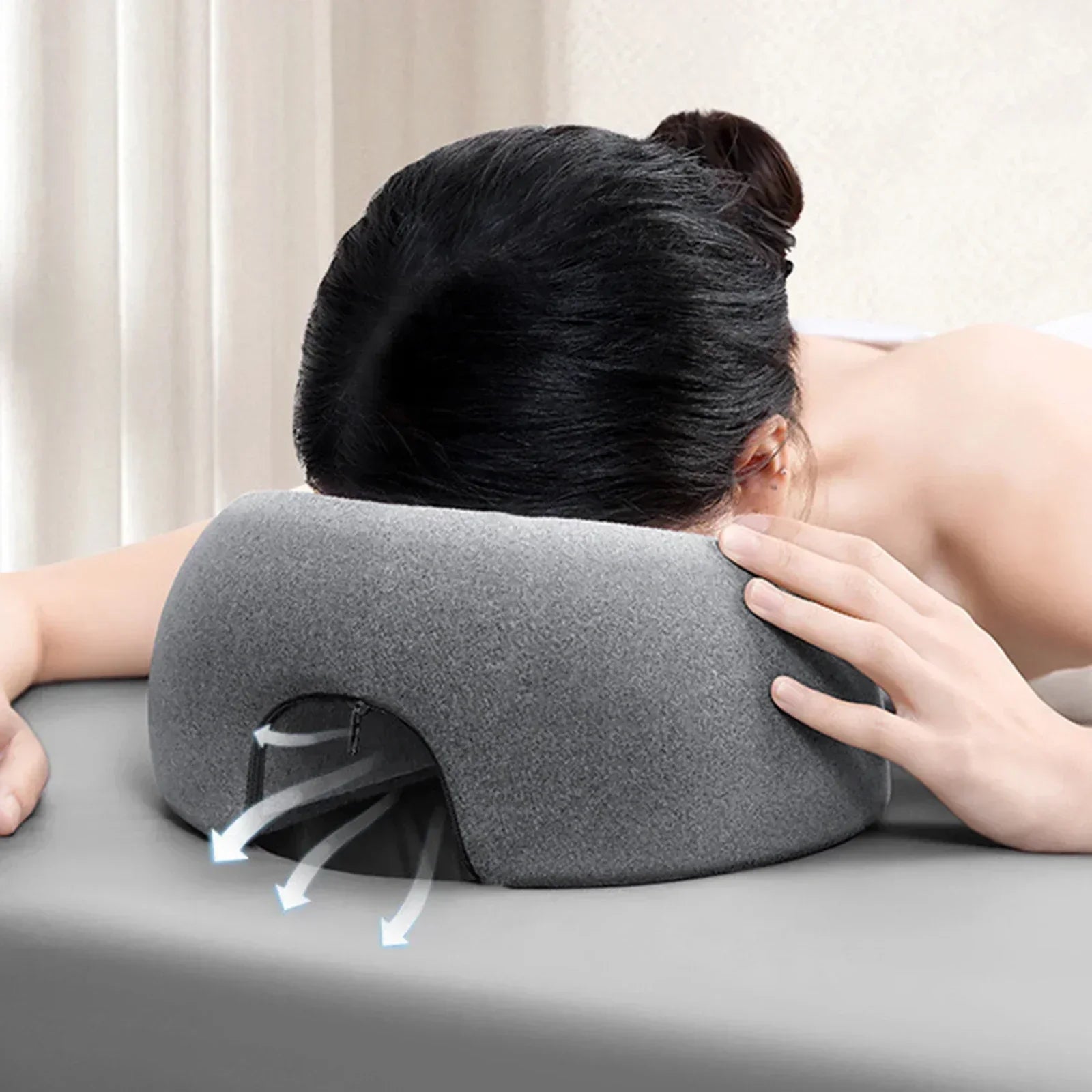 Cuscino ergonomico grigio per massaggi, supporto viso con fori di ventilazione, ideale per spa e relax, comfort e traspirabilità ottimali.