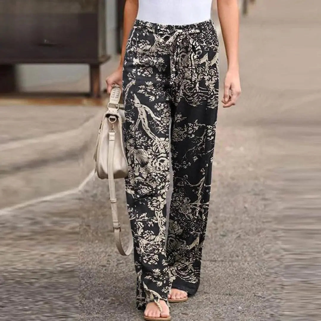 Pantaloni larghi donna con stampa floreale nera e beige, vita alta, tessuto leggero, stile casual, perfetti per l'estate.