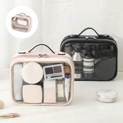 Due beauty case trasparenti con cerniera, uno rosa e uno nero, contenenti cosmetici e accessori da viaggio. Ideali per organizzare il trucco.