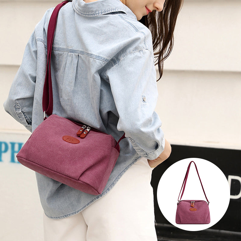 Donna con borsa a tracolla in tela rosa, design casual, indossa camicia di jeans. Borsa leggera, ideale per uso quotidiano e moda urbana.