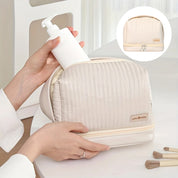 Borsa cosmetica beige con dispenser sapone, design trapuntato, chiusura a zip, ideale per organizzare trucchi e accessori da bagno.