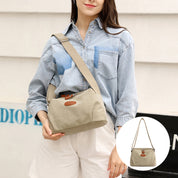 Donna con borsa a tracolla in tela beige, camicia di jeans e pantaloncini bianchi. Borsa casual, moda donna, accessorio estivo.