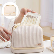 Borsa cosmetica beige con set di pennelli trucco, design trapuntato, chiusura a zip, ideale per organizzare accessori beauty.