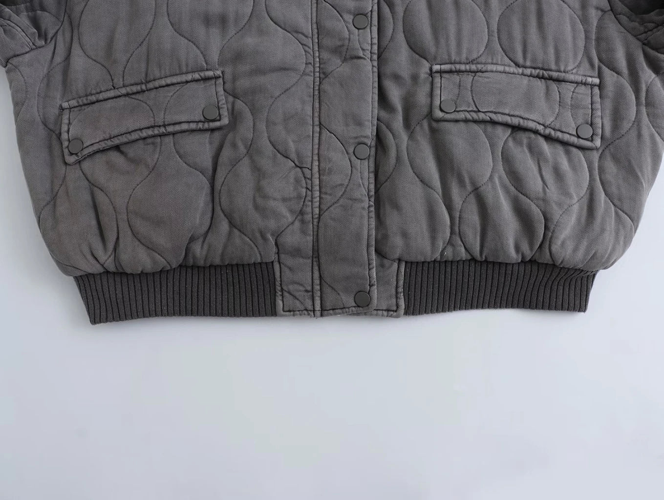 Giacca trapuntata grigia invernale, design moderno, chiusura a bottoni, tasche frontali, ideale per moda uomo, abbigliamento caldo e casual.