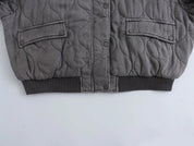 Giacca trapuntata grigia invernale, design moderno, chiusura a bottoni, tasche frontali, ideale per moda uomo, abbigliamento caldo e casual.