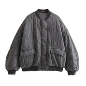 Giacca trapuntata oversize grigia, design a onde, chiusura a bottoni, tasche frontali, moda autunno inverno, stile casual e caldo.