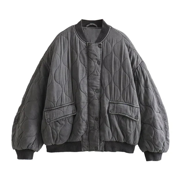 Giacca trapuntata oversize grigia, design a onde, chiusura a bottoni, tasche frontali, moda autunno inverno, stile casual e caldo.