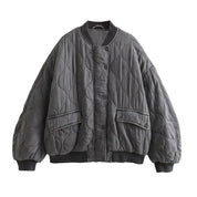 Giacca trapuntata oversize grigia, design a onde, chiusura a bottoni, tasche frontali, moda autunno inverno, stile casual e caldo.