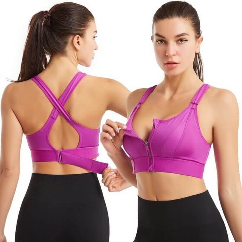 Due donne indossano reggiseni sportivi viola con cerniera frontale e spalline incrociate, ideali per fitness e yoga. Abbigliamento sportivo donna.