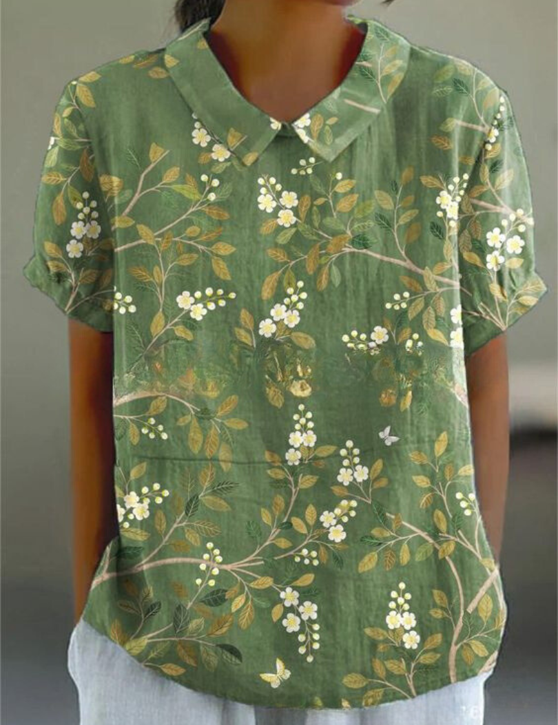 Camicia verde a maniche corte con stampa floreale bianca e gialla, colletto classico, stile casual estivo, tessuto leggero e traspirante.