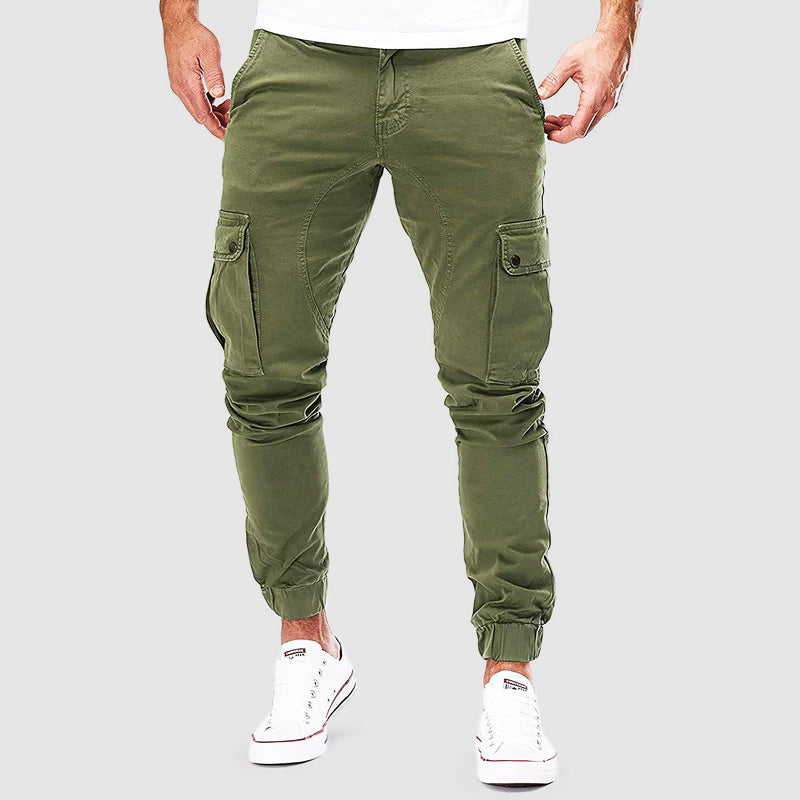 Pantaloni cargo uomo verde militare, tasche laterali, vestibilità slim, stile casual, abbigliamento maschile, moda urbana, scarpe bianche.