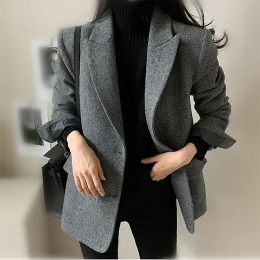 Giacca donna elegante grigia, stile casual chic, abbinata a maglione nero. Moda autunnale, outfit versatile per ufficio o uscite informali.