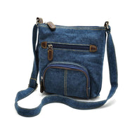 Borsa a tracolla in denim blu con tasche multiple e dettagli in pelle marrone. Design casual, ideale per uso quotidiano e moda urbana.