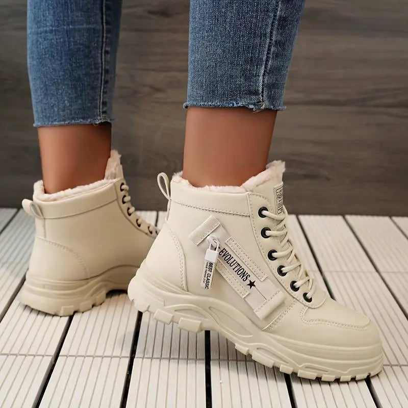 Stivaletti beige da donna con pelliccia, suola robusta e lacci neri, indossati con jeans. Scarpe invernali moda, comode e calde.