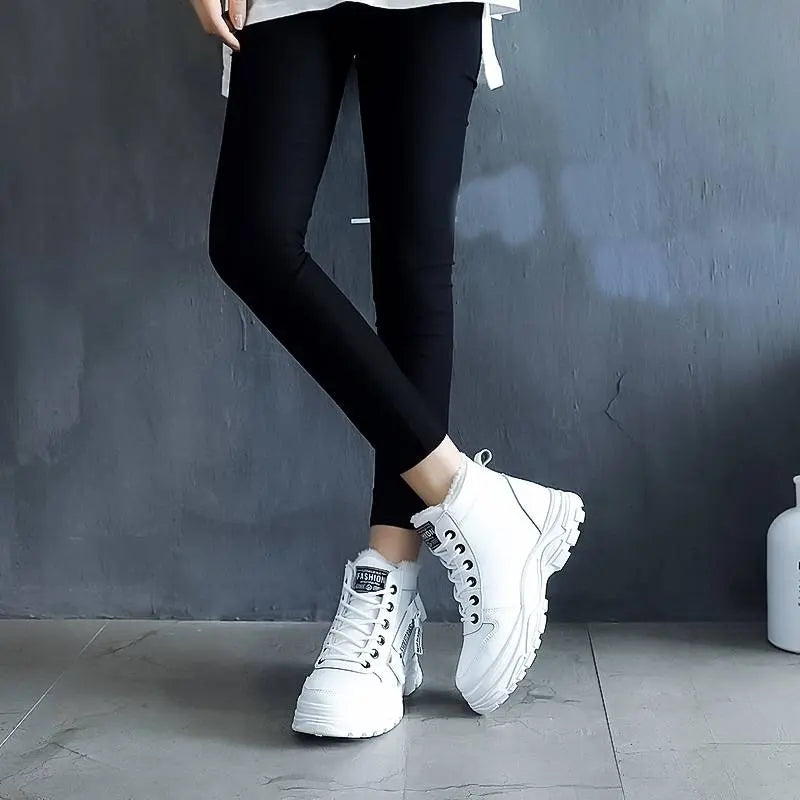 Pantaloni neri aderenti e scarpe da ginnastica bianche su sfondo grigio. Scarpe sportive alla moda, calzature casual donna.