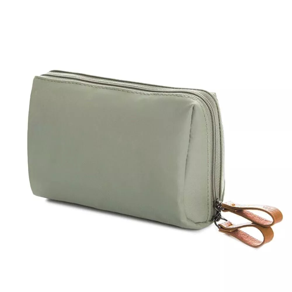 Astuccio da viaggio verde oliva con doppia cerniera e tiralampo in pelle marrone, ideale per cosmetici e accessori. Design elegante e funzionale.