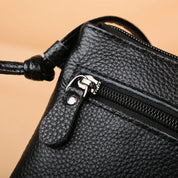 Borsa a tracolla in pelle nera con cerniera, texture a grana, design elegante e moderno, accessorio moda donna, alta qualità.