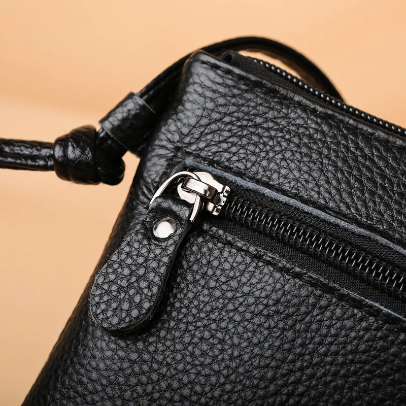 Borsa a tracolla in pelle nera con cerniera, texture a grana, design elegante e moderno, accessorio moda donna, alta qualità.