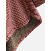 Giacca invernale a quadri rossi e bianchi, interno in pile beige, chiusura con bottone. Abbigliamento caldo e alla moda per la stagione fredda.