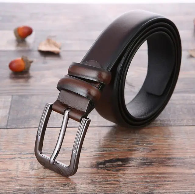 Cintura in pelle marrone scuro con fibbia in metallo su sfondo di legno, accessorio moda uomo elegante e versatile.